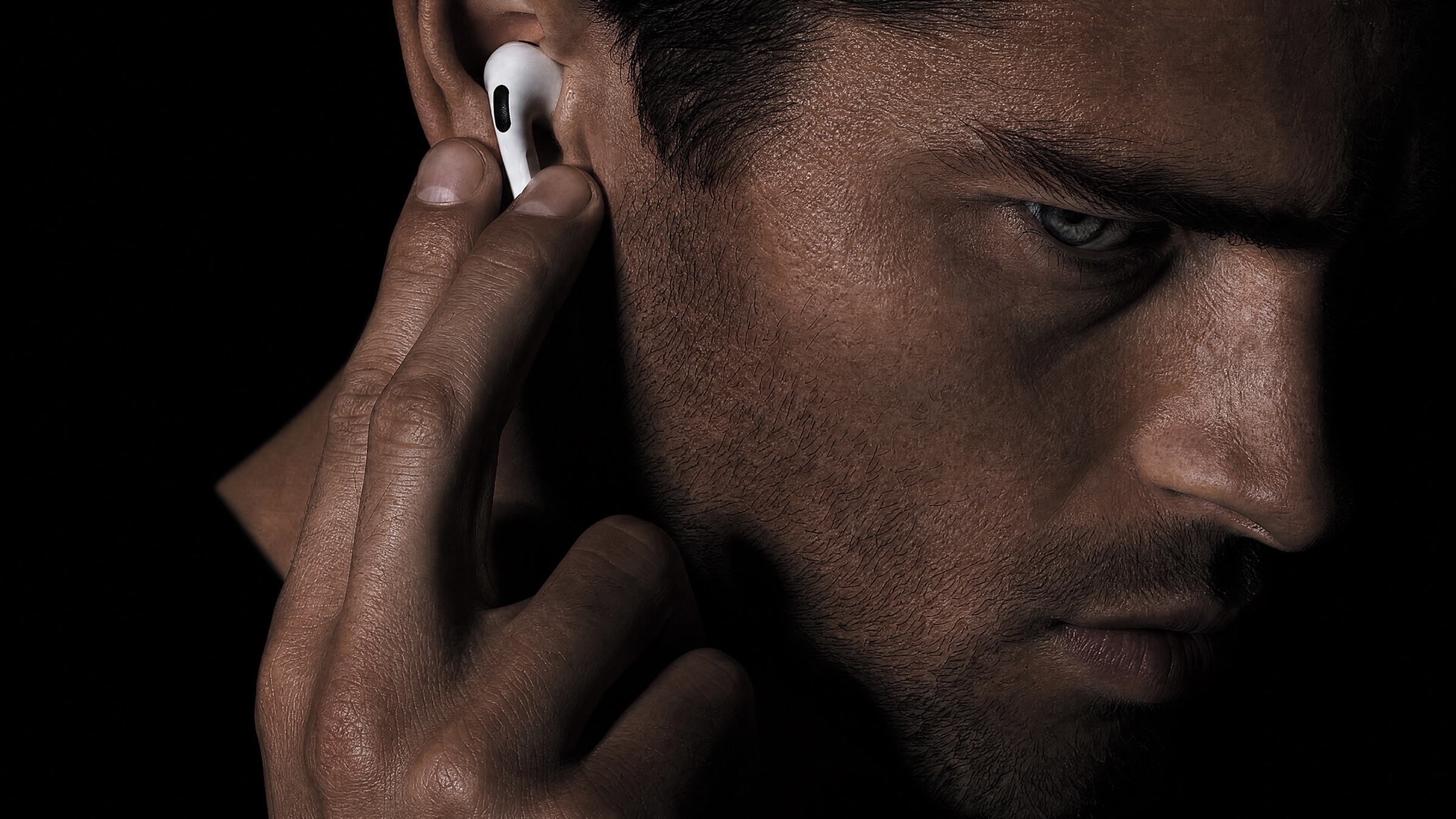 Close portrait, an earbud held to the ear
